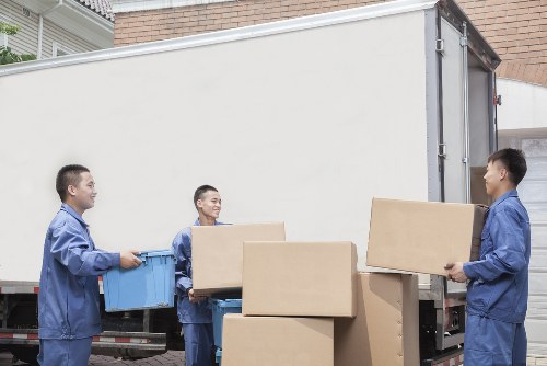 Workers using team lifting techniques during a removal job
